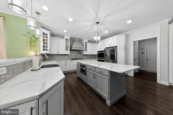 a large kitchen with kitchen island a sink stainless steel appliances and cabinets