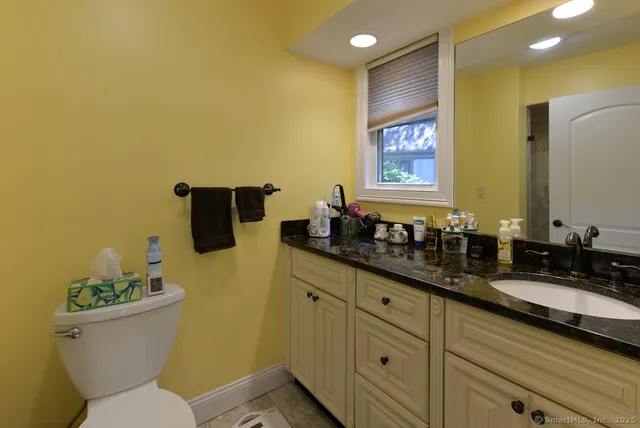 a bathroom with a granite countertop sink and a mirror