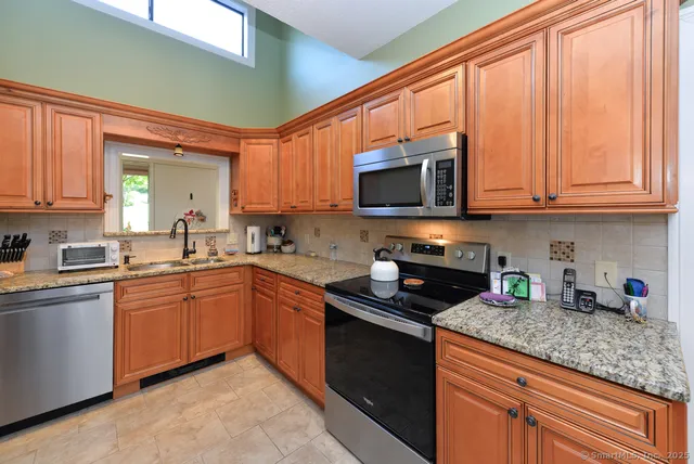 a kitchen with stainless steel appliances granite countertop a stove sink microwave and cabinets