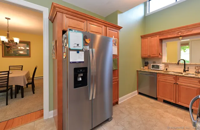 a kitchen with stainless steel appliances granite countertop a refrigerator and a sink