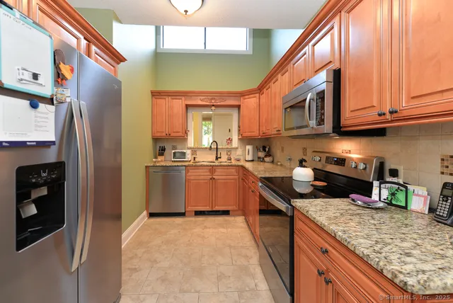 a kitchen with stainless steel appliances granite countertop a stove a sink and a refrigerator