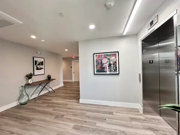 a view of a hallway with wooden floor and furniture