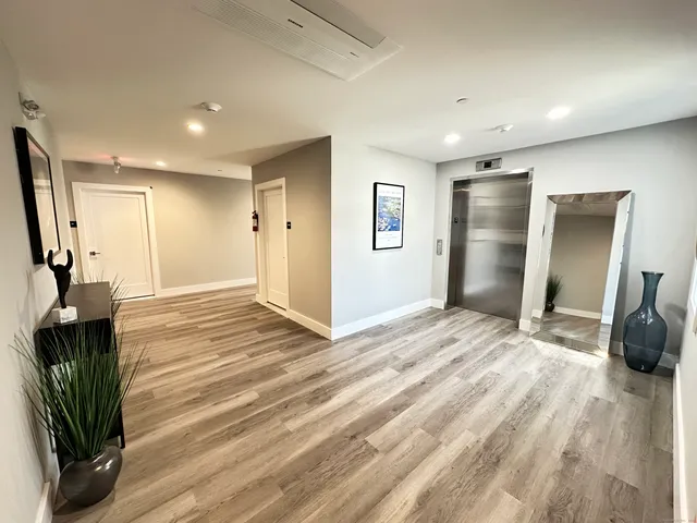 a view of a livingroom with wooden floor and a ceiling fan