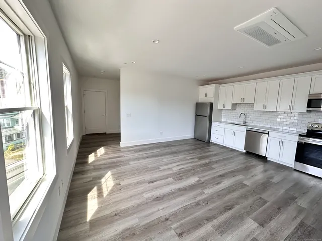 a view of a kitchen with wooden floor and electronic appliances