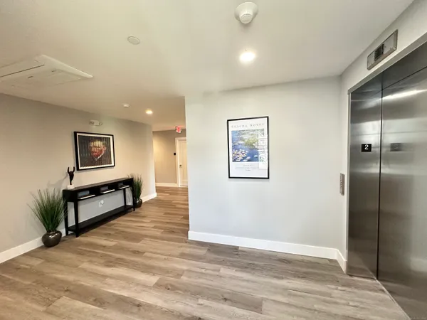a view of a hallway with wooden floor and furniture