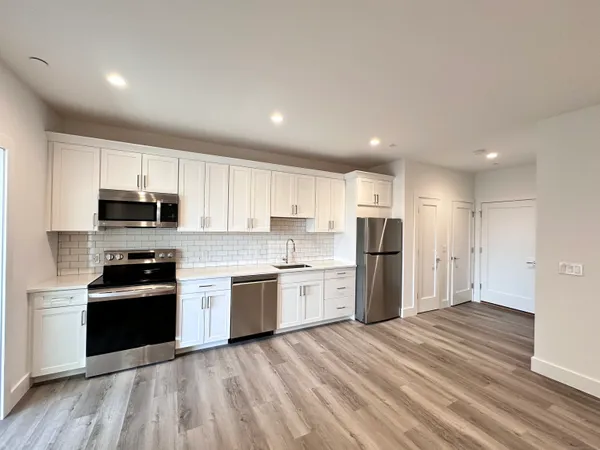a kitchen with a refrigerator stove top oven and sink