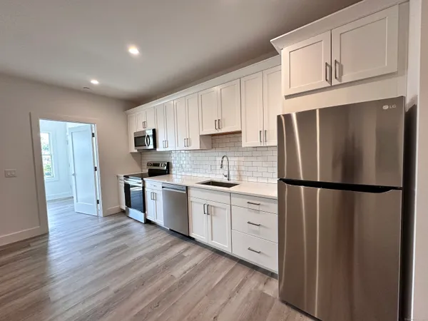 a kitchen with stainless steel appliances a refrigerator sink and cabinets