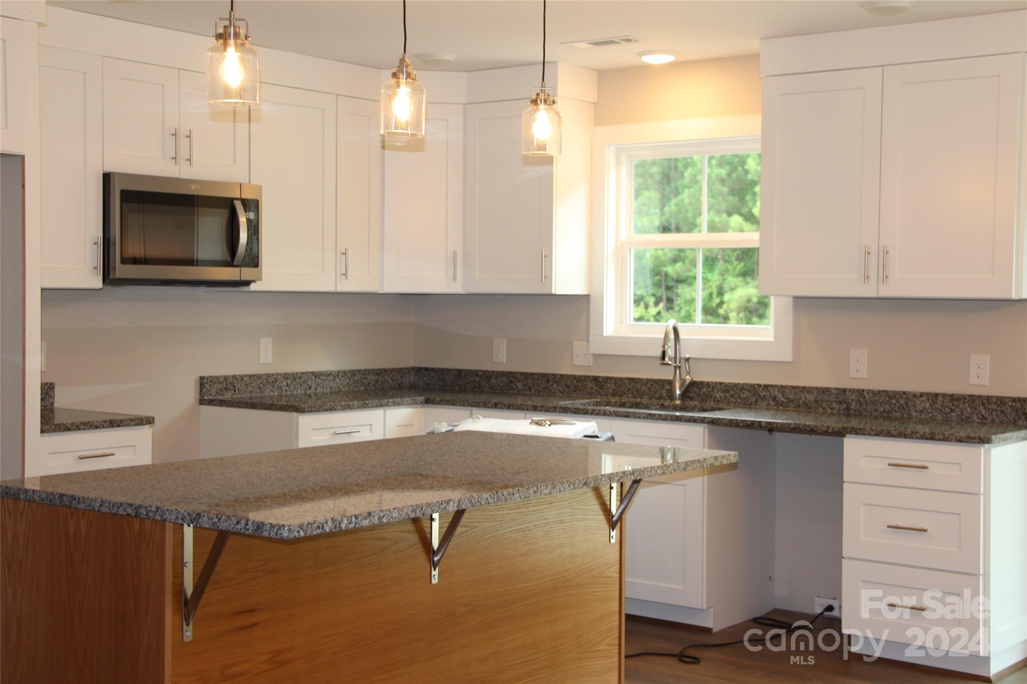 4222 Fletcher Funderburk Road Lancaster, SC 29720 - Photo 7 of 18 a kitchen with granite countertop a sink a counter space appliances and cabinets