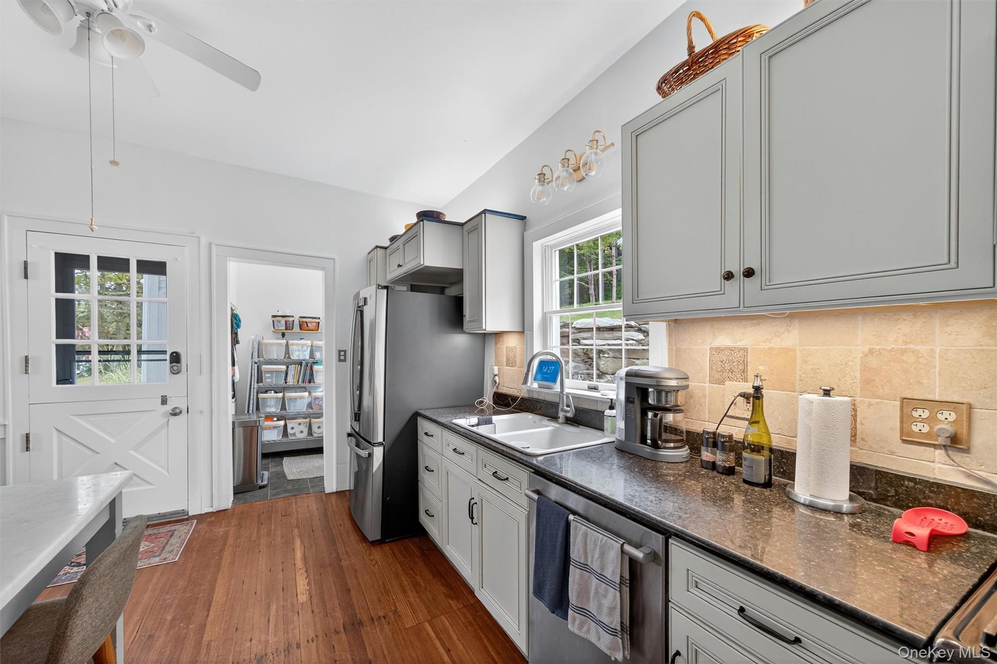 1657 River Road Damascus, PA 18415 - Photo 19 of 43 Kitchen featuring appliances with stainless steel finishes, dark wood-type flooring, gray cabinets, backsplash, and a ceiling fan