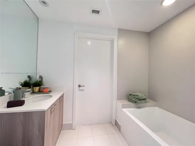 a bathroom with a bathtub sink and mirror