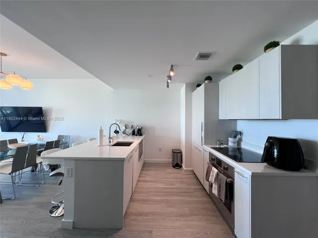 a kitchen with a sink a stove and cabinets