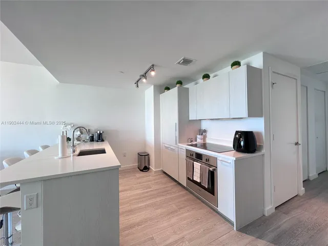 a kitchen with a stove a sink and a refrigerator