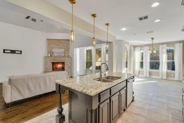 a kitchen with granite countertop sink and refrigerator