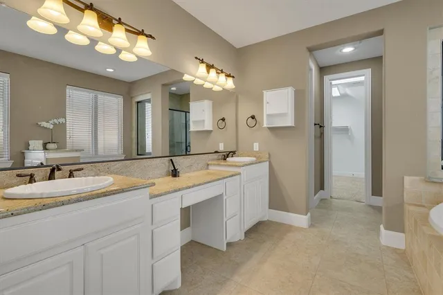 a spacious bathroom with a granite countertop sink a mirror and a shower