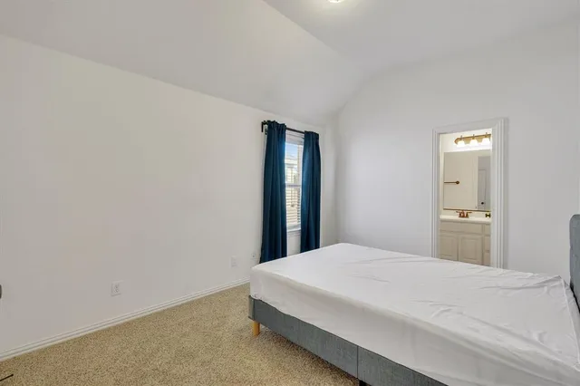 a bed sitting in a bedroom next to a window