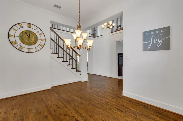 a view of a room with wooden floor chandelier and entryway