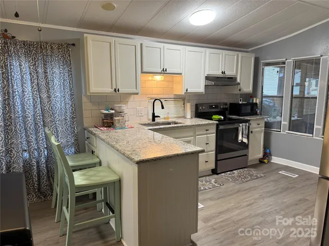 a kitchen with granite countertop a sink stove and refrigerator