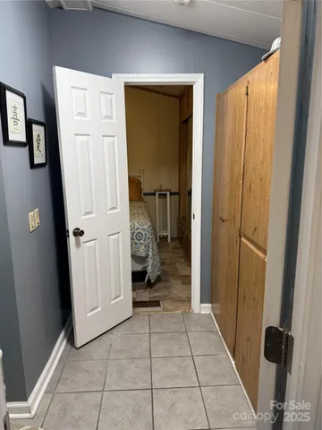 a view of a hallway with wooden floor and a livingroom