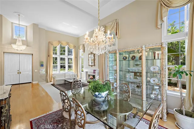 a dining room with furniture a potted plant and open kitchen view