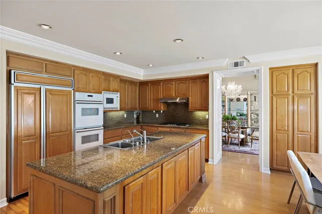 a kitchen with stainless steel appliances granite countertop a sink refrigerator and cabinets