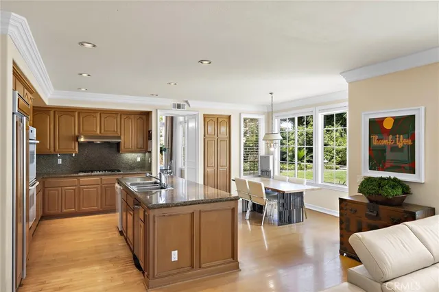 a large living room with stainless steel appliances granite countertop a couch a table and chairs