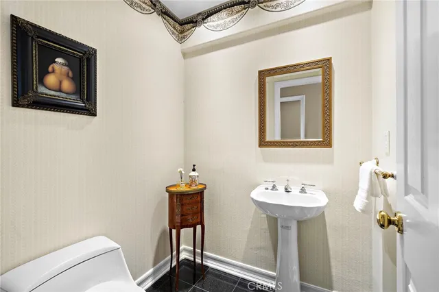 a bathroom with a sink toilet and mirror