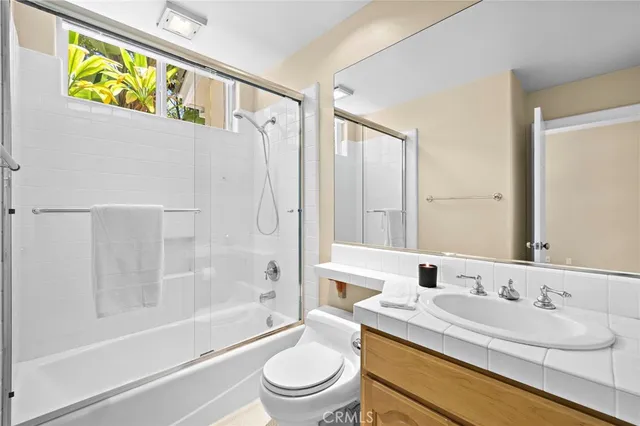 a bathroom with a granite countertop sink toilet a mirror and bathtub
