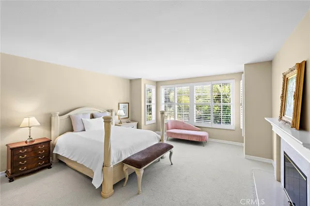 a spacious bedroom with a bed and a flat screen tv