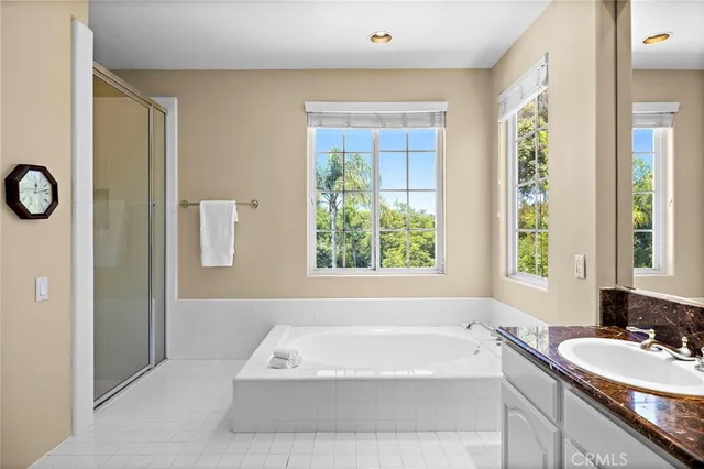 a bathroom with a tub a sink and a window