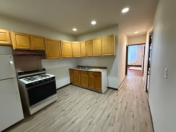 a kitchen with granite countertop wooden floors and stainless steel appliances
