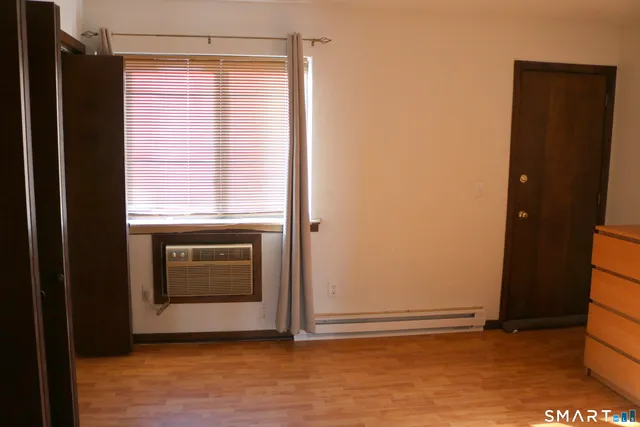 a view of an empty room with a fireplace and a window
