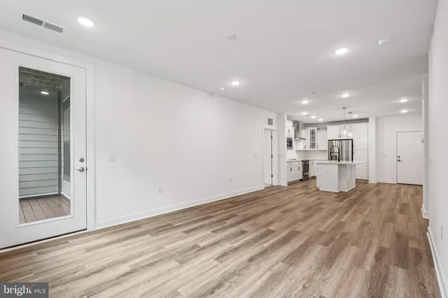 a view of an empty room with a window and cabinet