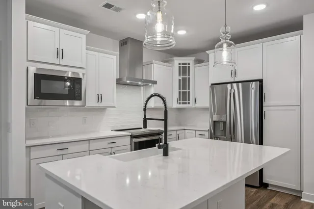 a kitchen with kitchen island a sink stainless steel appliances and cabinets