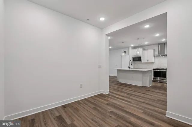 a view of a kitchen with wooden floor and windows