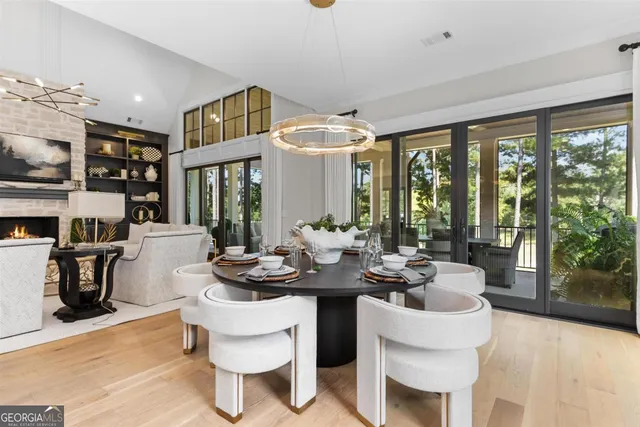 a kitchen with granite countertop a stove a sink dishwasher a dining table and chairs with wooden floor