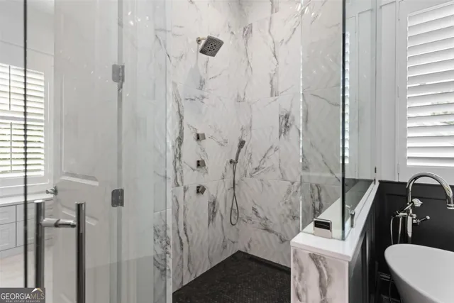 a bathroom with a granite countertop sink a toilet a shower and a mirror