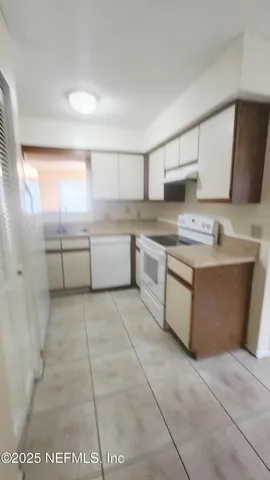a kitchen with stainless steel appliances granite countertop a sink counter space cabinets and a large window