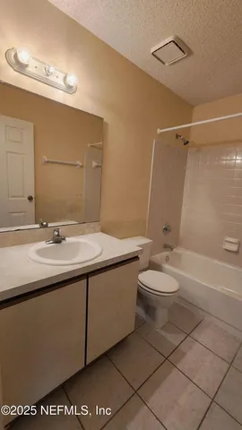 a bathroom with a granite countertop sink a toilet and mirror