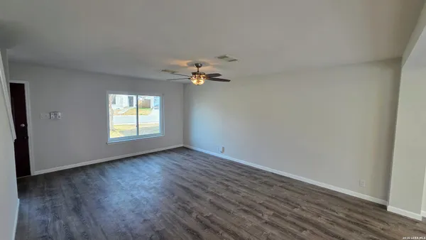 wooden floor in an empty room with a window