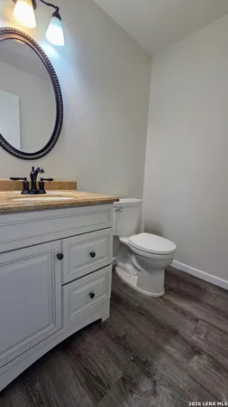 a bathroom with a toilet a sink and mirror