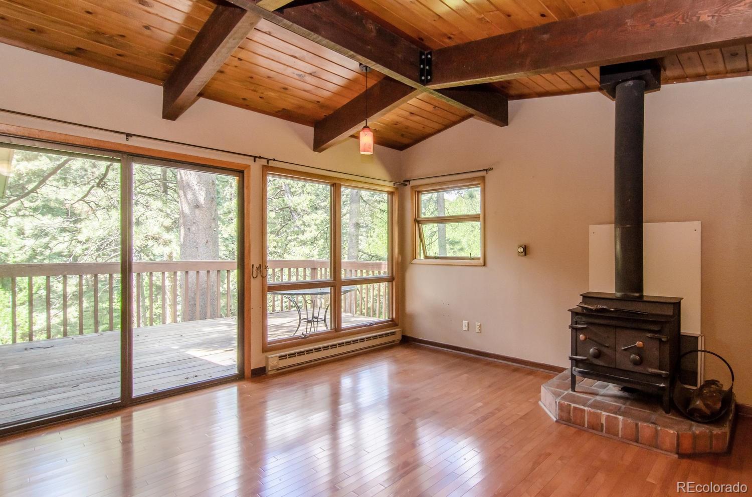 31463 Upper Bear Creek Road Evergreen, CO 80439 - Photo 15 of 23 a view of an empty room with wooden floor and a window