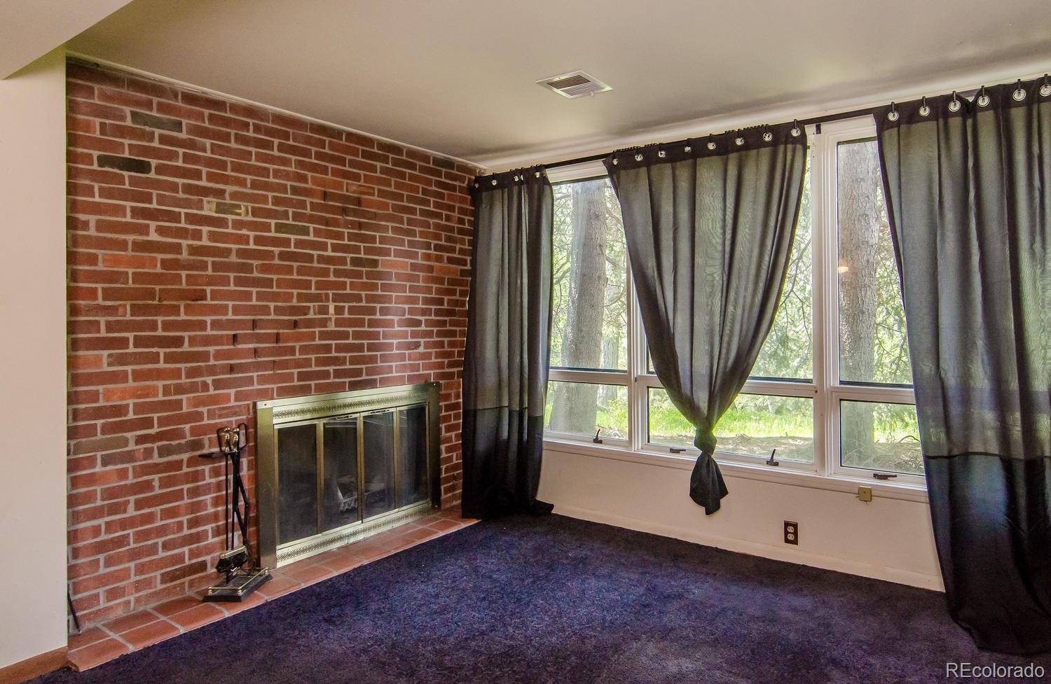 31463 Upper Bear Creek Road Evergreen, CO 80439 - Photo 18 of 23 a view of an empty room with a fireplace and a window