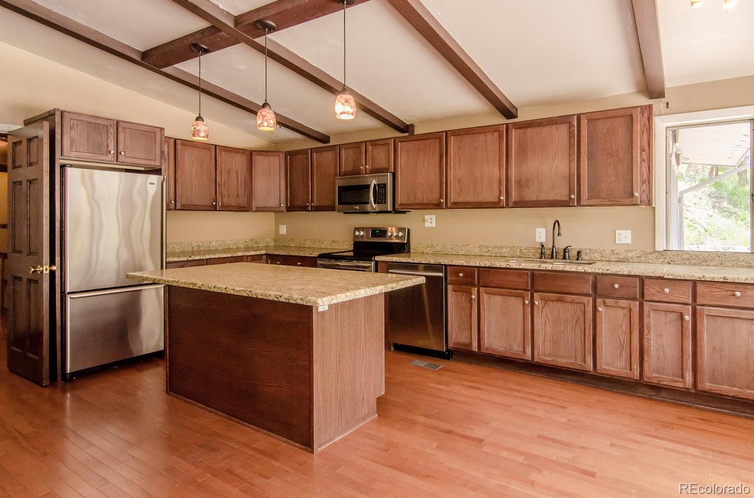 31463 Upper Bear Creek Road Evergreen, CO 80439 - Photo 9 of 23 a kitchen with stainless steel appliances granite countertop a refrigerator a sink dishwasher a stove top oven a refrigerator and cabinets