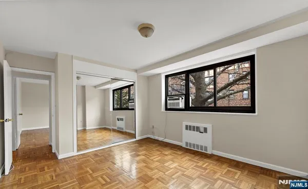 a view of an empty room with window and bathroom
