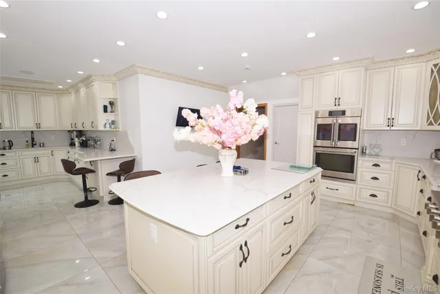 a large kitchen with kitchen island a sink a stove and a refrigerator