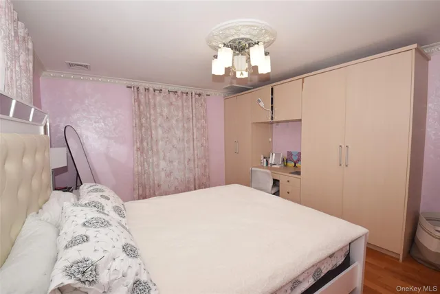 a bedroom with a large bed and a chandelier