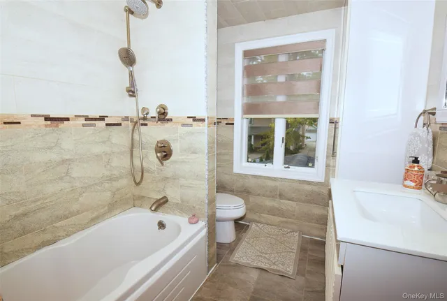 a bathroom with a tub a toilet and a shower