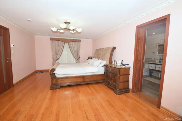 a spacious bedroom with a bed and a chandelier