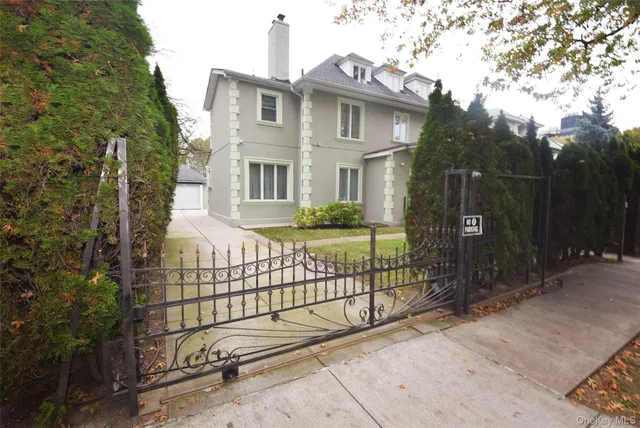 a view of a brick house with a small yard and wooden fence