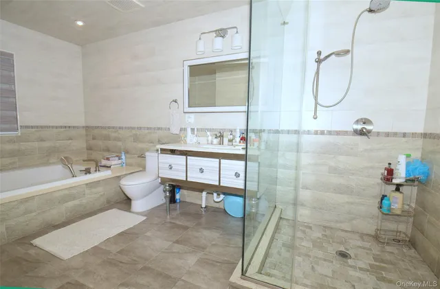 a bathroom with a granite countertop sink a toilet and bathtub